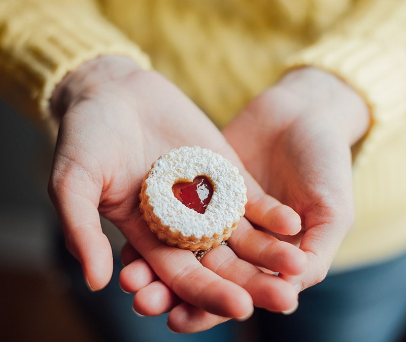 Une femme perplexe tenant un ordinateur portable avec une notification de cookies à l'écran, intitulée « Devriez-vous accepter les cookies ? »